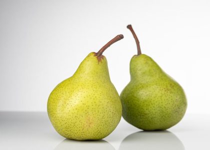 Bright and fresh green pears on a clean white background, symbolizing healthy eating and fresh produce.